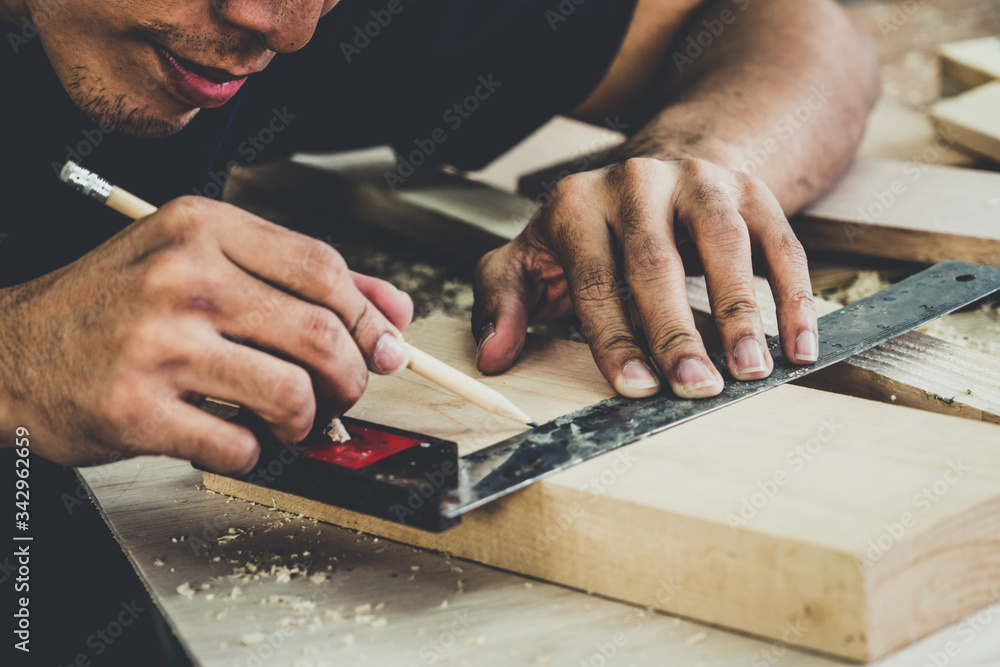 Carpenter working on wood craft at workshop to produce construction material or wooden furniture. Th