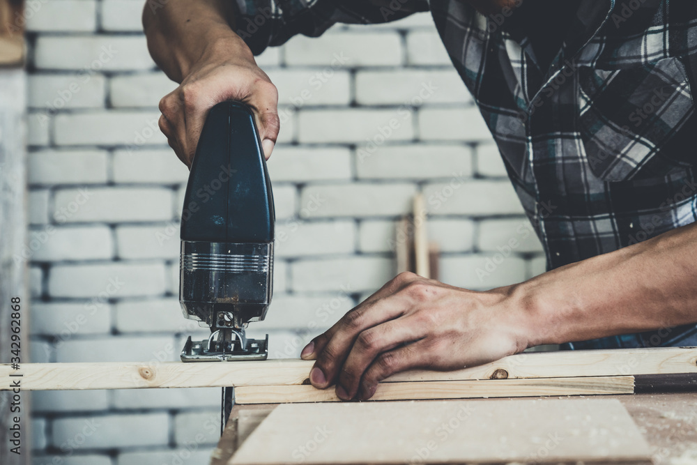 Carpenter working on wood craft at workshop to produce construction material or wooden furniture. Th