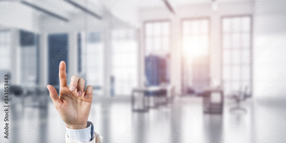 Choosing gesture of businessperson in elegant modern interior in sunshine light