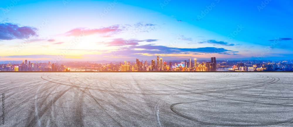 空旷的赛道，日落时的重庆城市天际线和建筑，中国。