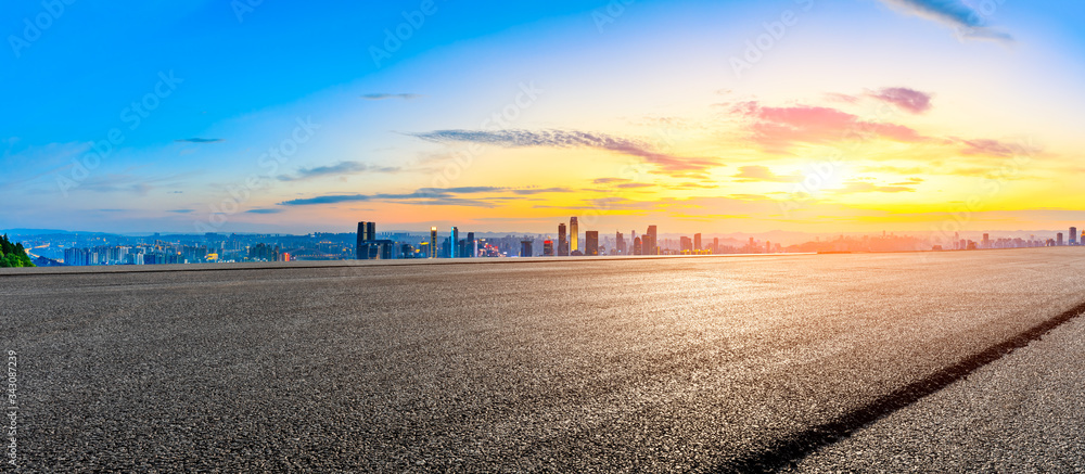 空旷的柏油路，日落时的重庆城市天际线和建筑，中国。