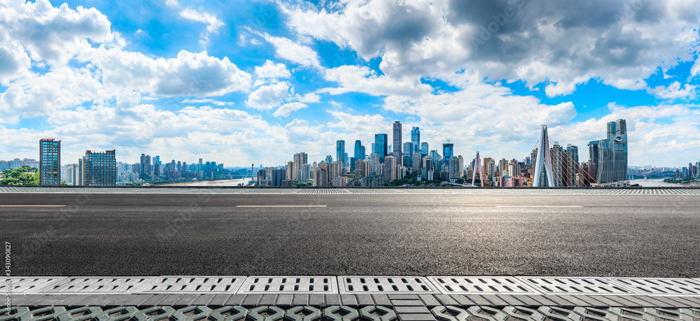 空旷的柏油路和重庆的城市天际线和建筑景观，中国。