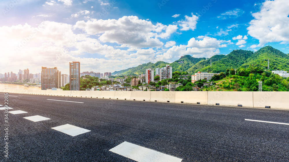 空旷的柏油公路、重庆的天际线和建筑景观，中国。