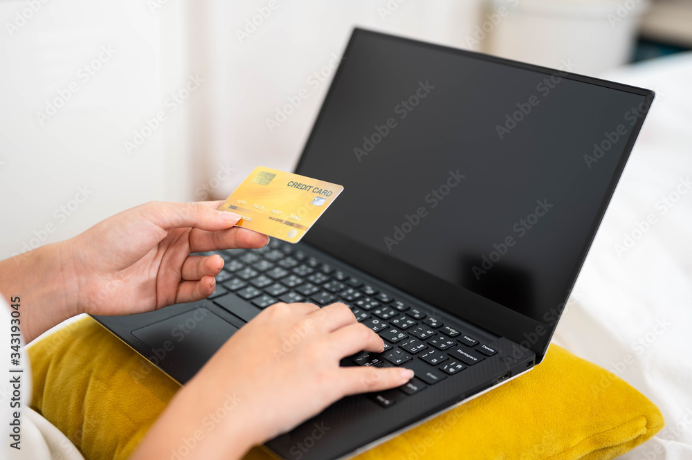 Young woman holding credit card using for online shopping,ordering,purchase in laptop