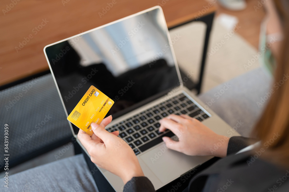 Young woman holding credit card using for online shopping,ordering,purchase in laptop