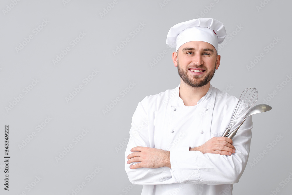 Handsome male chef on light background