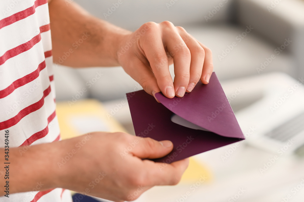 Young man with letter at home, closeup