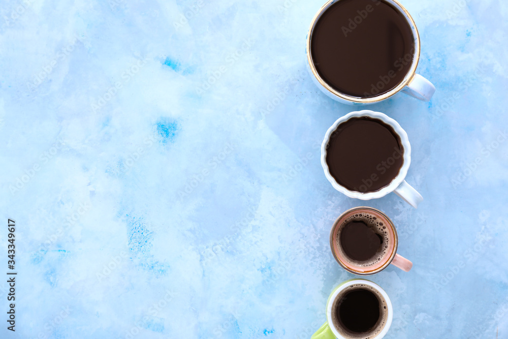 Cups of coffee on color background