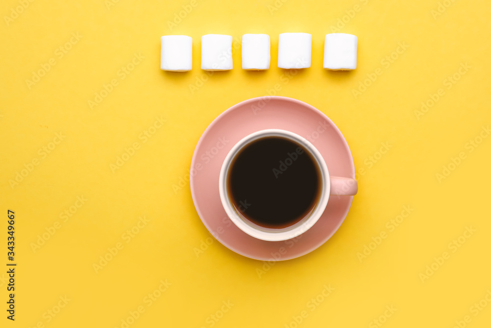 Cup of coffee with marshmallows on color background