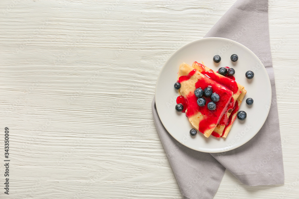 Tasty blini with berries on table