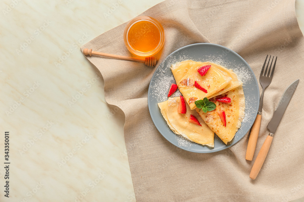 Tasty blini with berries and honey on table