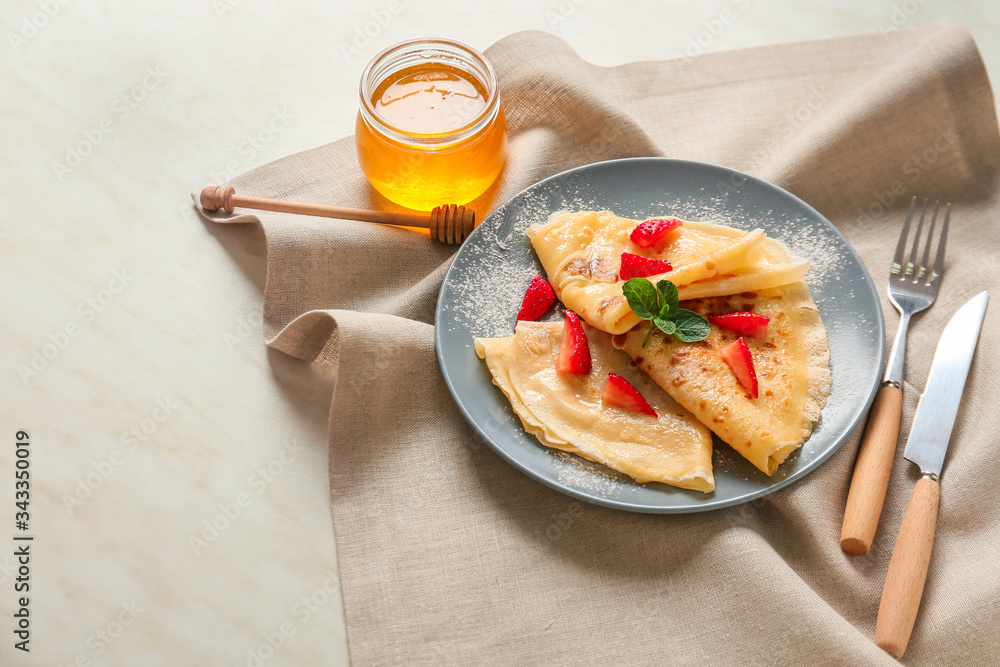 Tasty blini with berries and honey on table