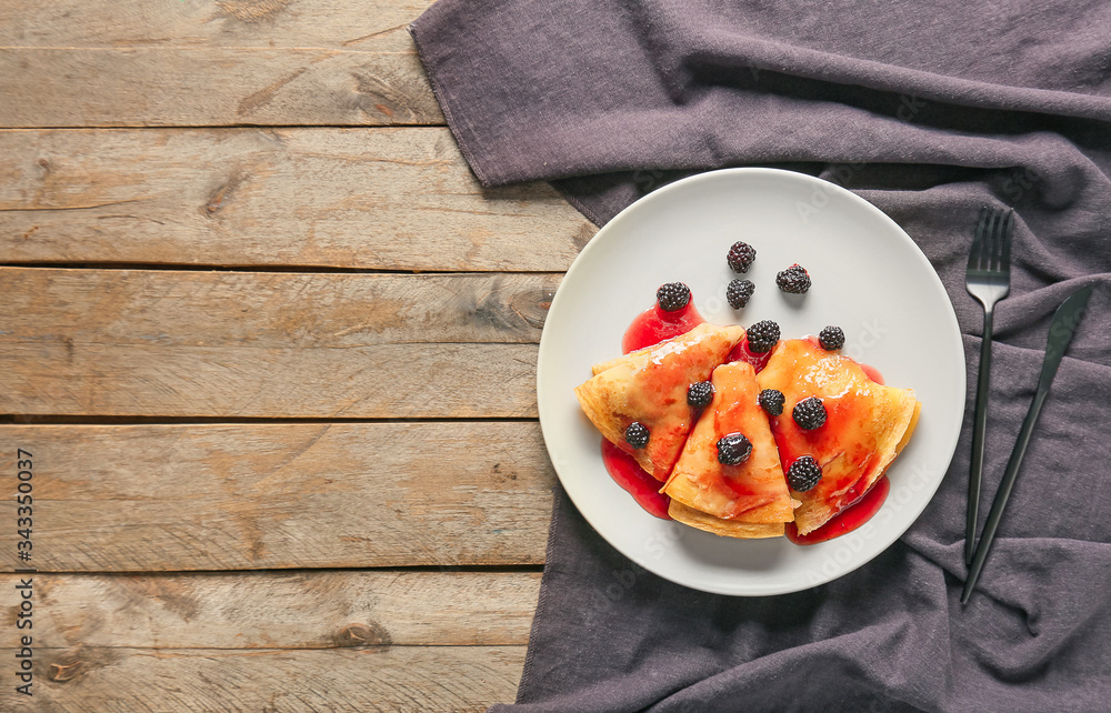 Tasty blini with berries on table