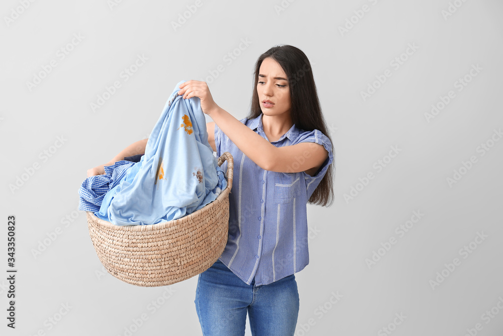 浅色背景下穿着脏衣服的年轻女子被驱散