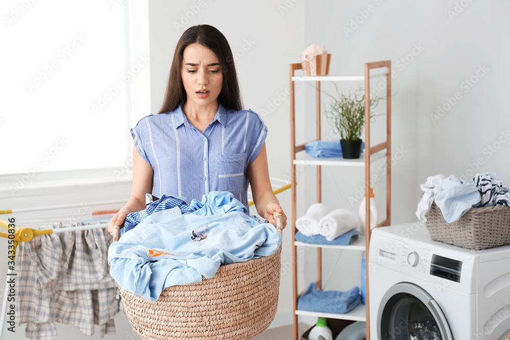 Displeased young woman doing laundry at home