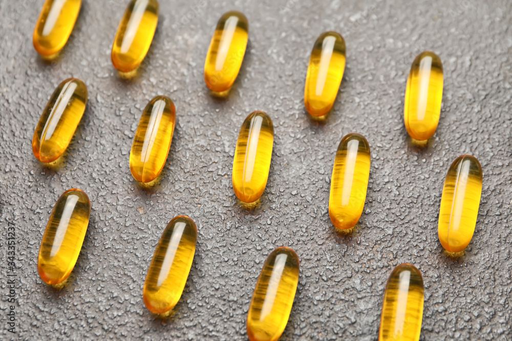 Fish oil capsules on grey background