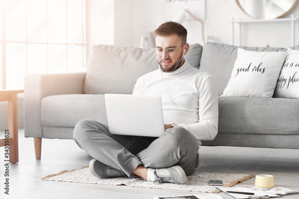 Young man with laptop working at home