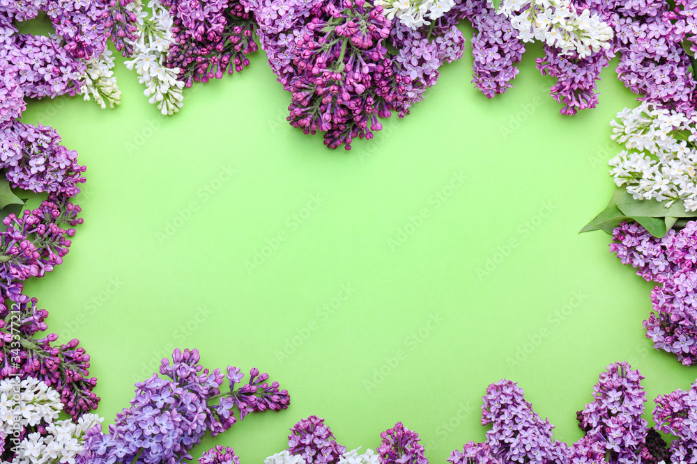 Frame made of beautiful lilac flowers on color background