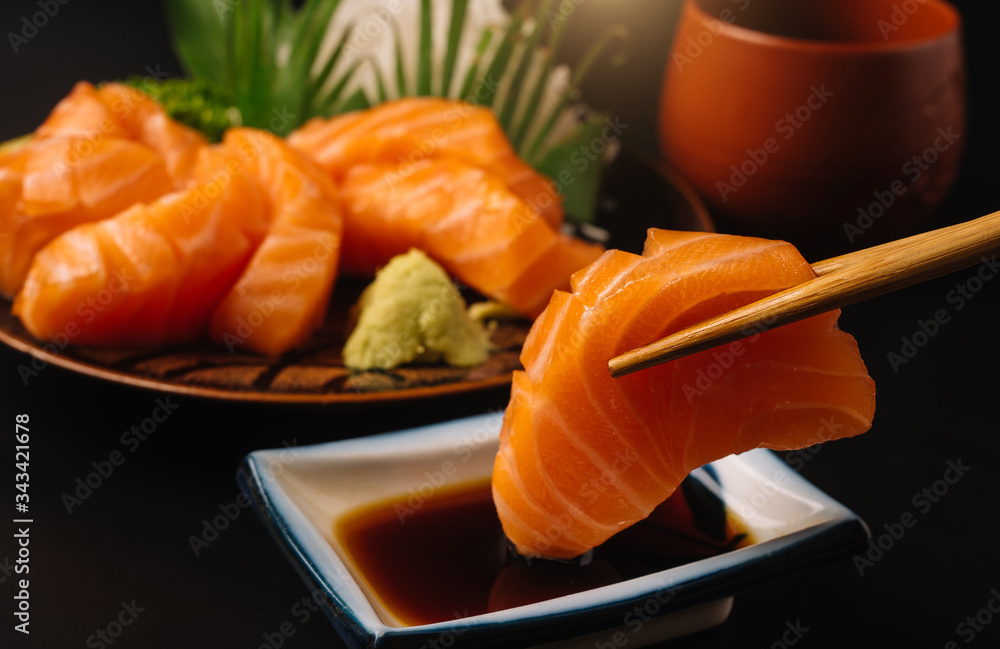 Sashimi, Salmon, Japanese food chopsticks and wasabi on the wood table
