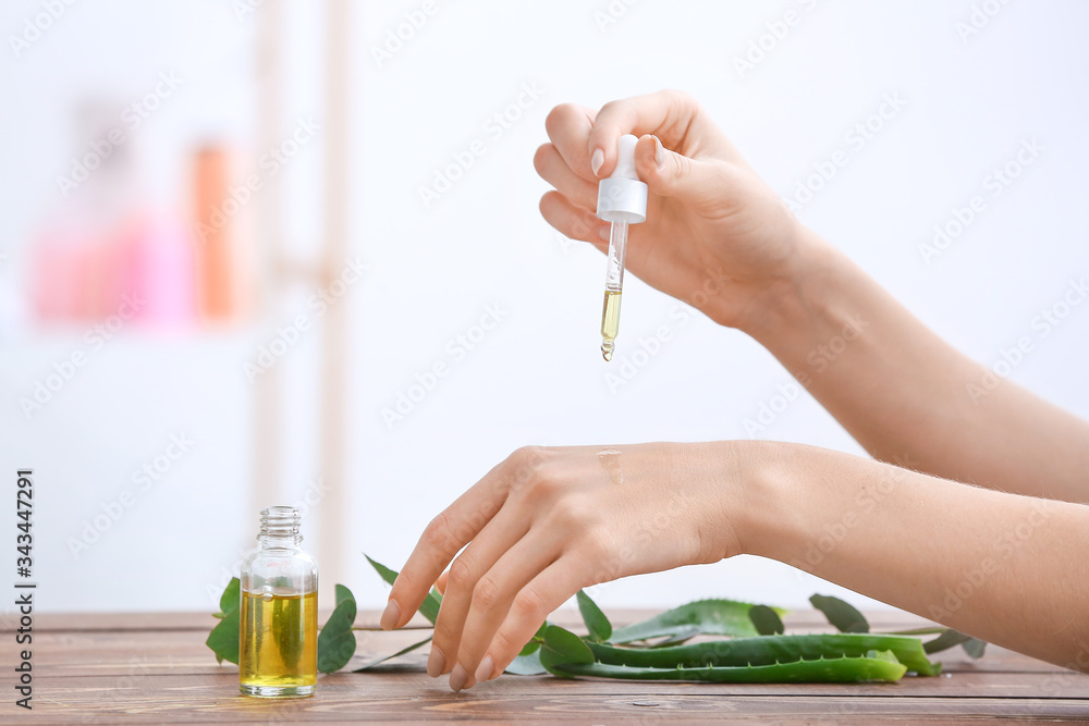 Woman applying essential oil on her hands