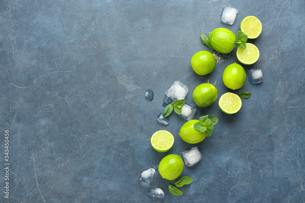 Fresh limes and ice cubes on dark background