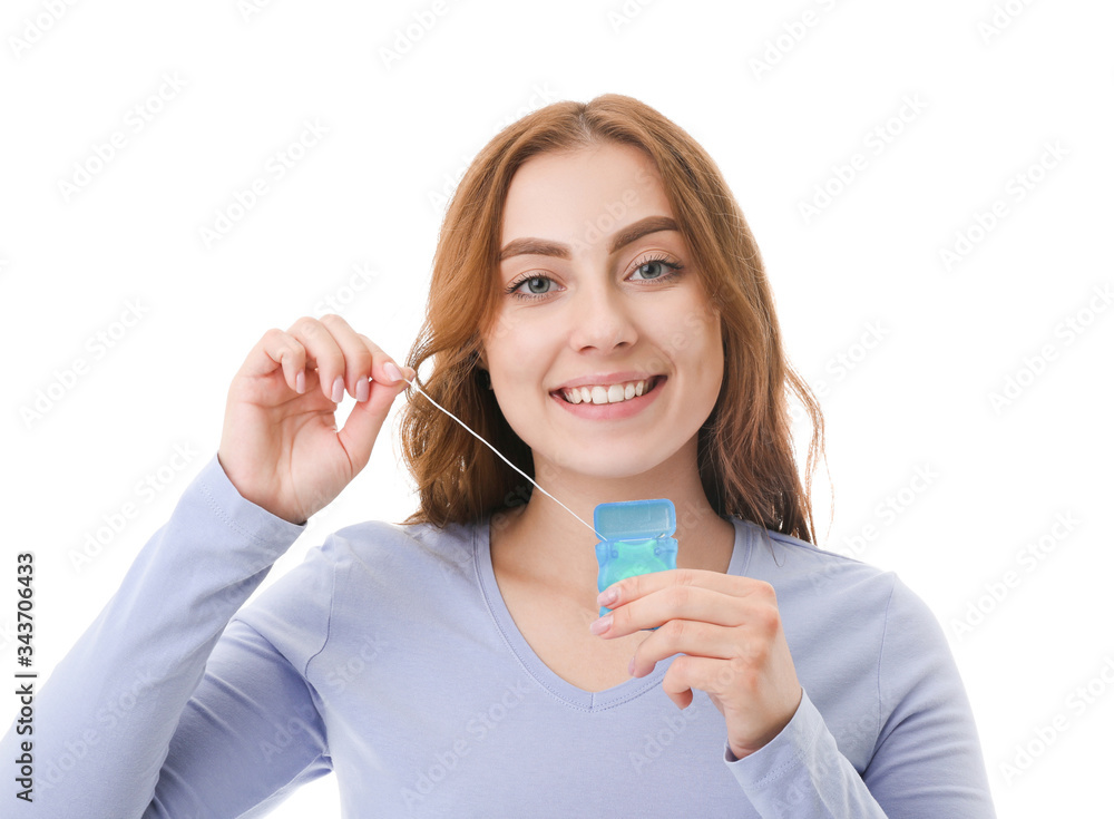 Beautiful young woman with dental floss on white background