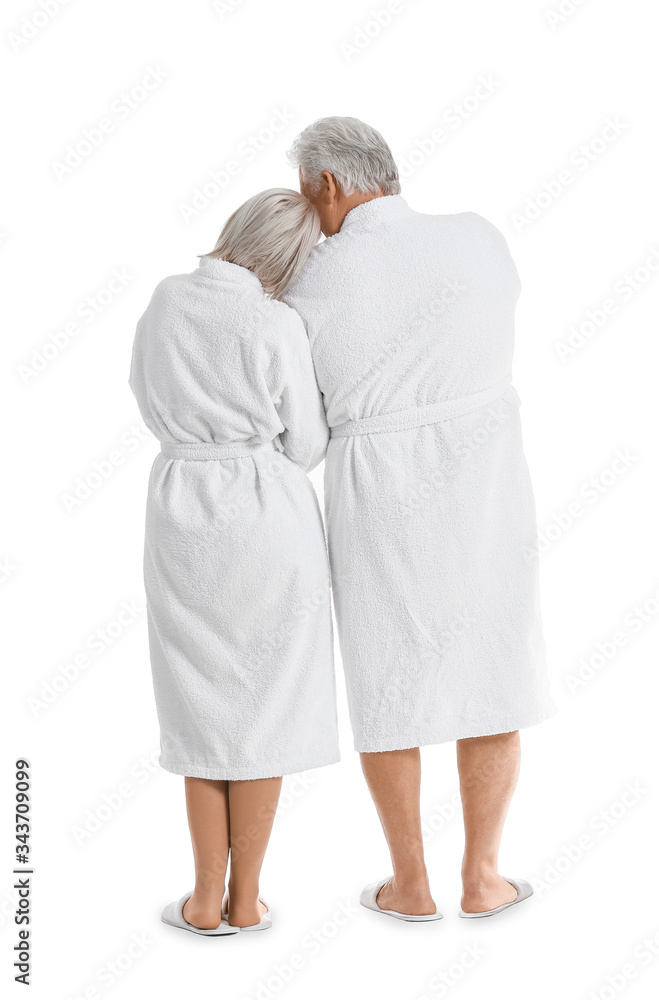 Mature couple in bathrobes on white background, back view