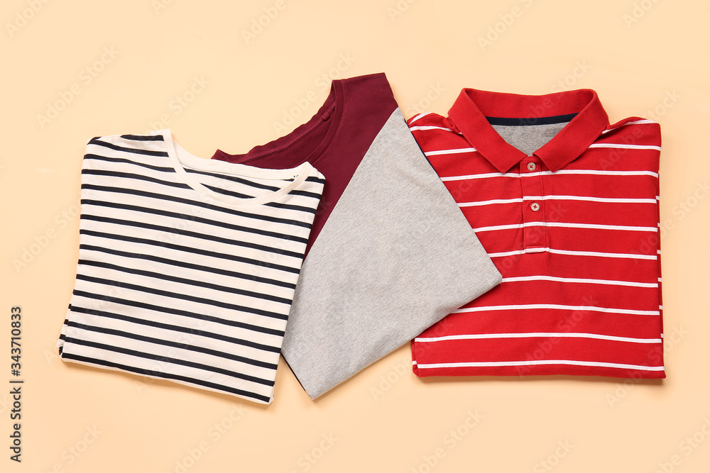 Stylish t-shirts on color background