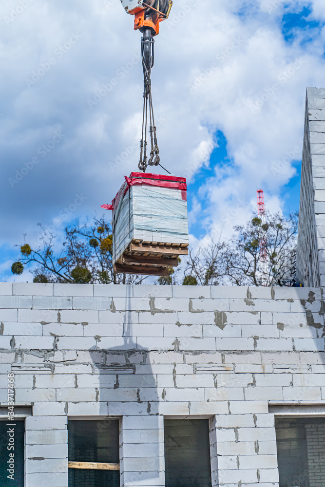 蓝天前的建筑起重机。建造高高的住宅楼。