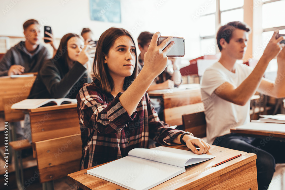 Students recording the lecture in classroom