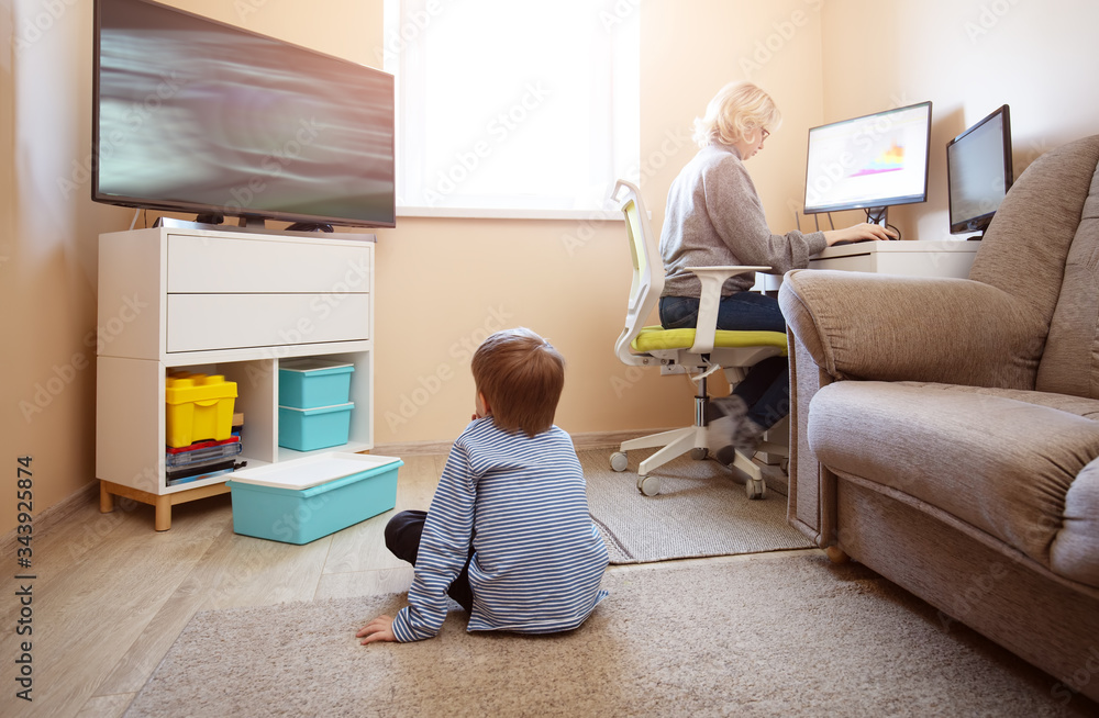 woman working at home with little child.