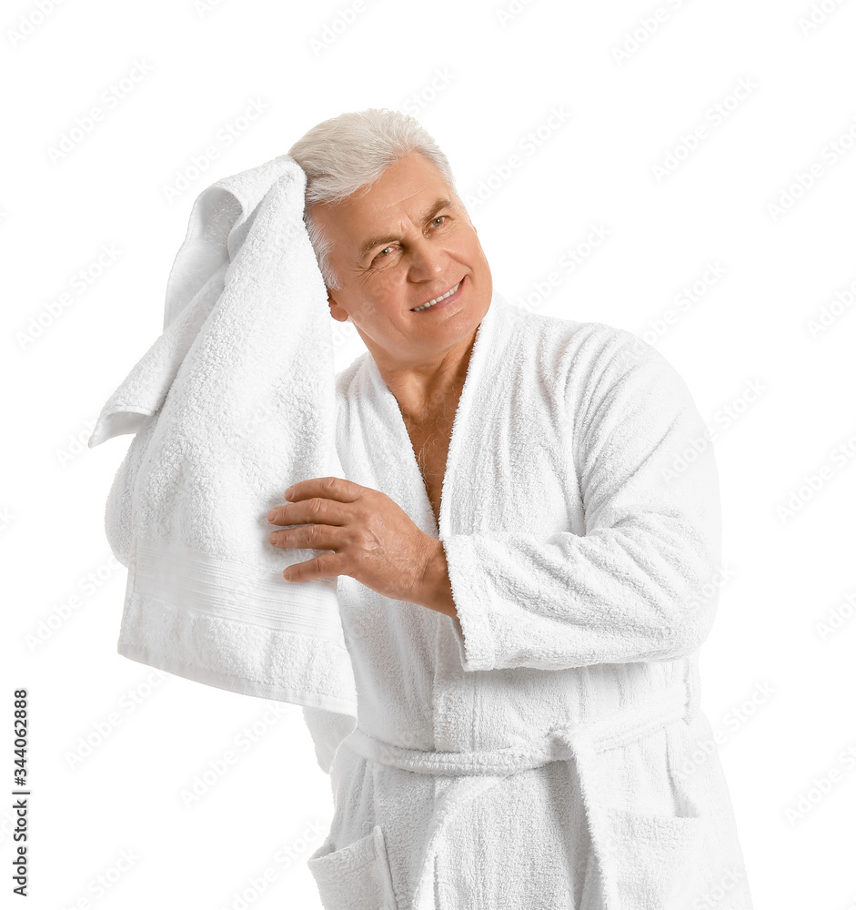 Happy mature man in bathrobe and with towel on white background