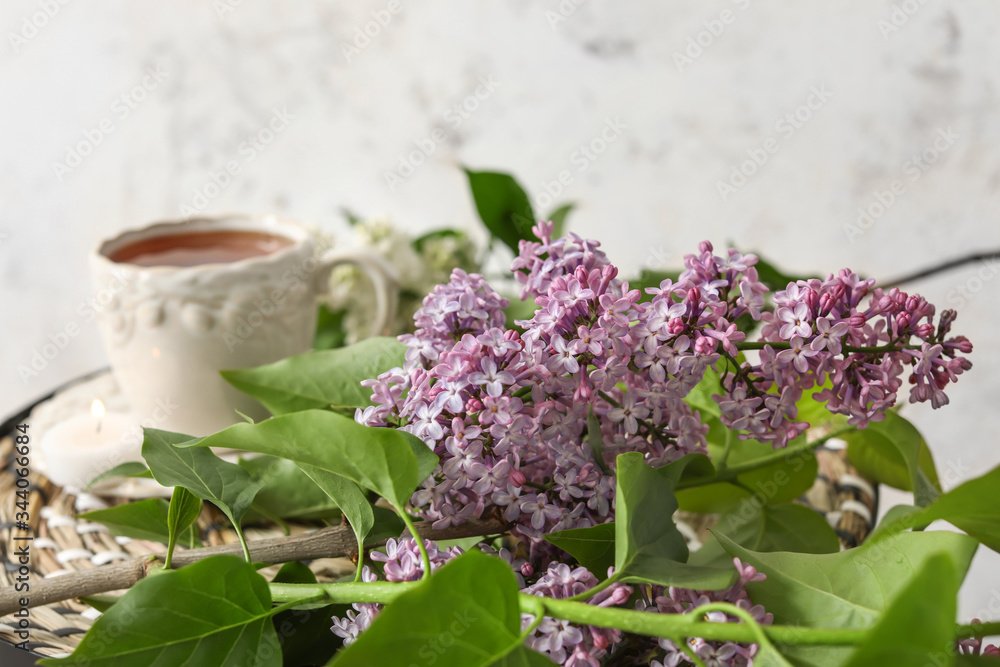 美丽的淡紫色花朵，桌上放着一杯茶，特写