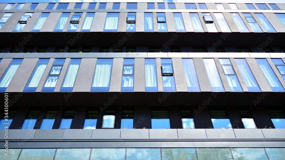 Modern office building windows with vertical lines and reflection. Building reflecting the sky with 