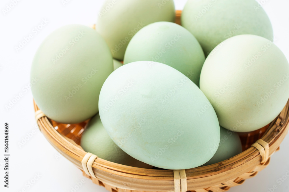 Black eggs in green shell on white background