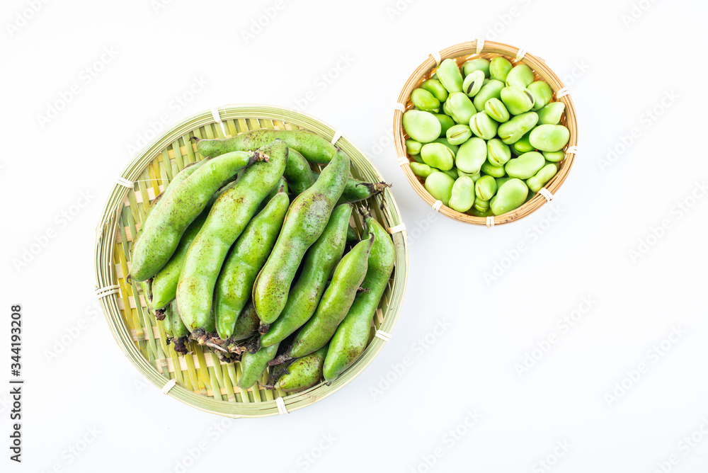 Fresh broad bean pods and broad beans on white background