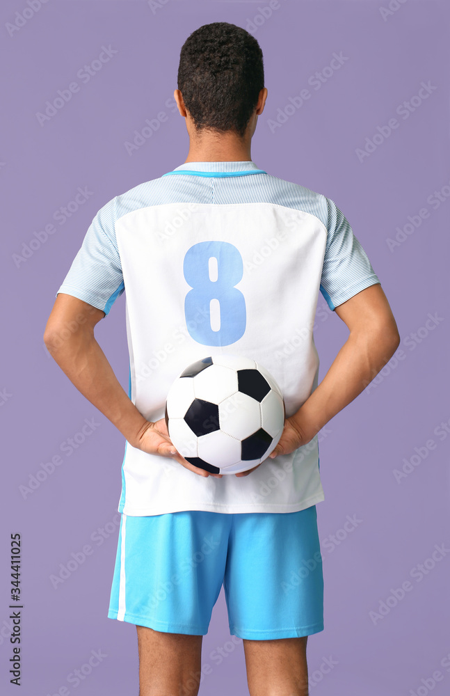 Young African-American football player on color background, back view