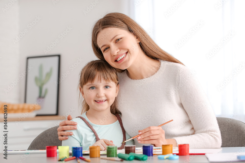 Drawing teacher giving private art lessons to little girl at home