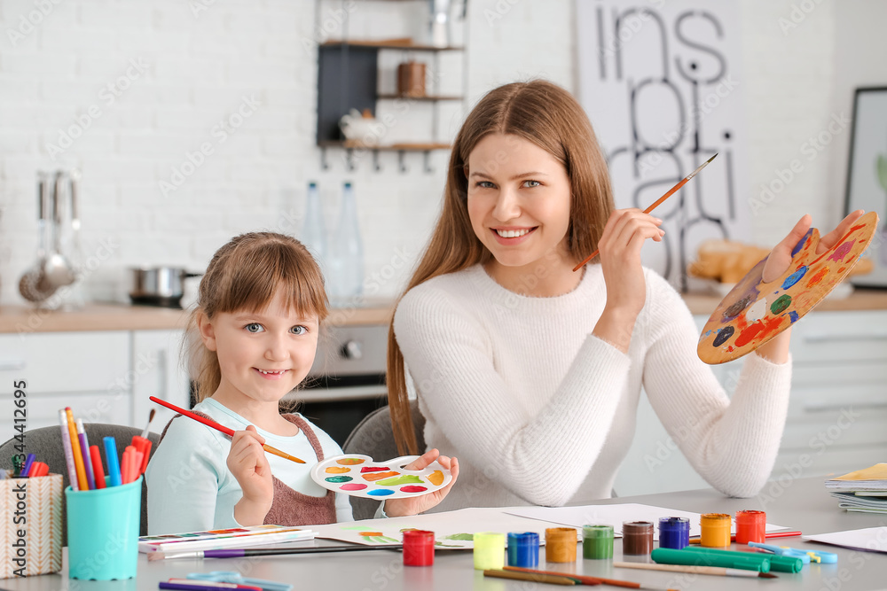 Drawing teacher giving private art lessons to little girl at home