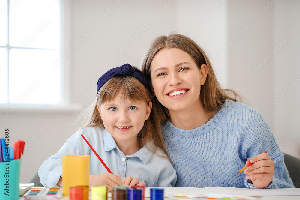 Drawing teacher giving private art lessons to little girl at home