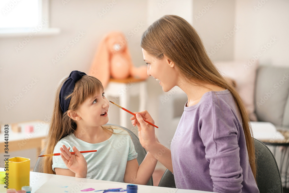 Drawing teacher giving private art lessons to little girl at home