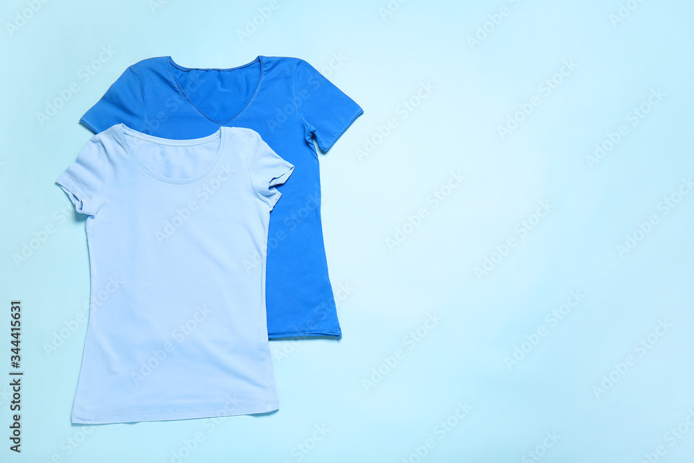 Stylish t-shirts on color background