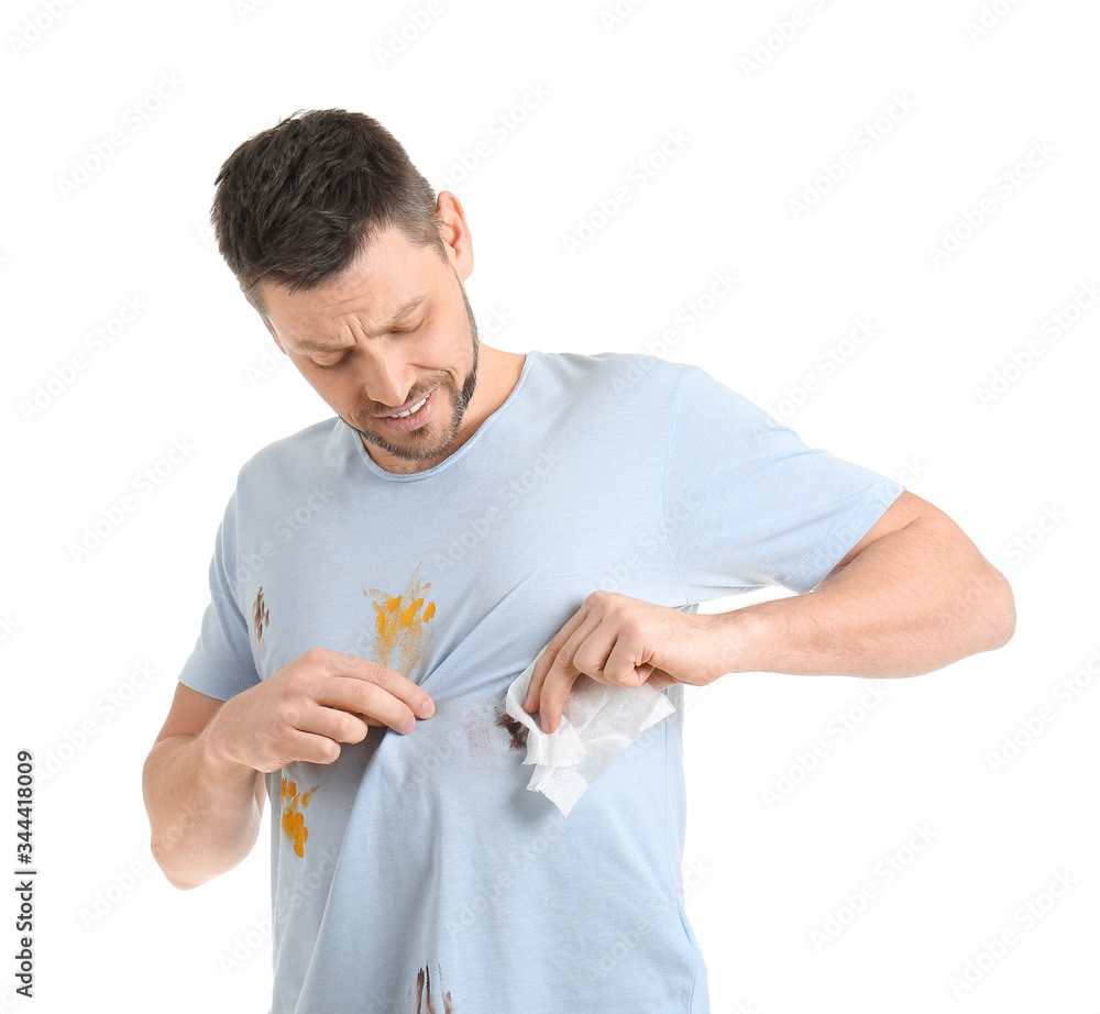 Displeased man wiping dirt from clothes on white background