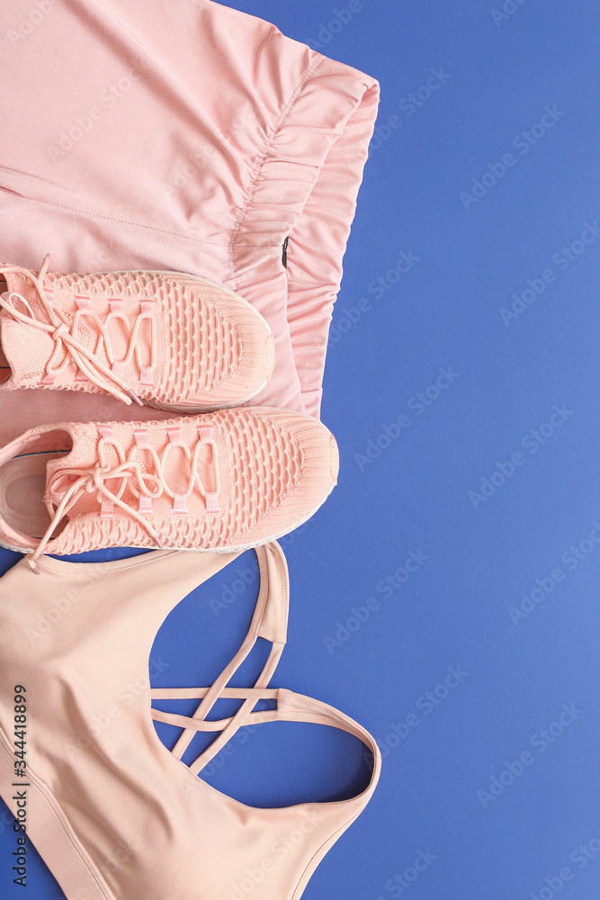 Female sportswear on color background