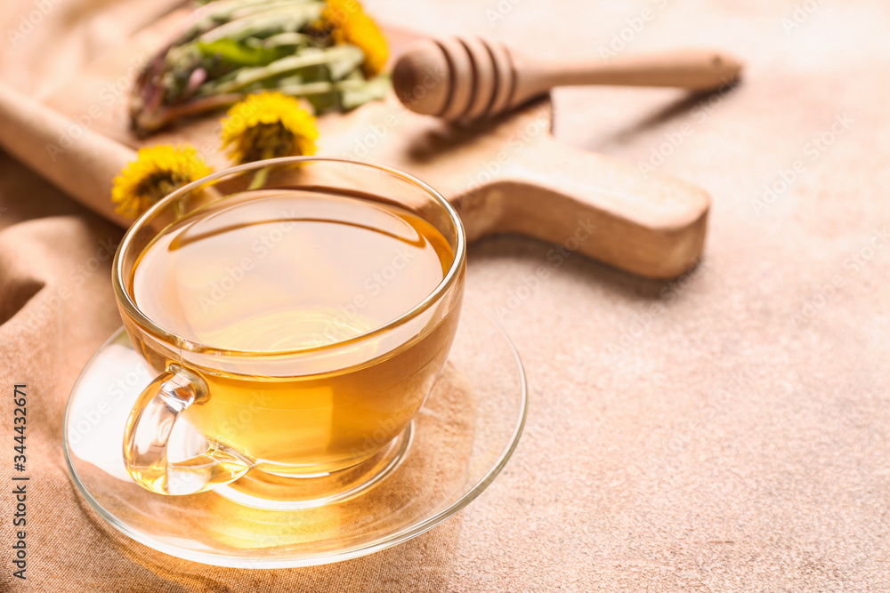 Cup of healthy dandelion tea on grey background