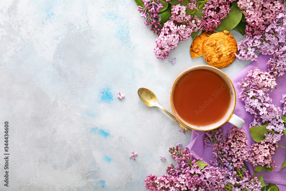 Beautiful lilac flowers, tea and cookies on table