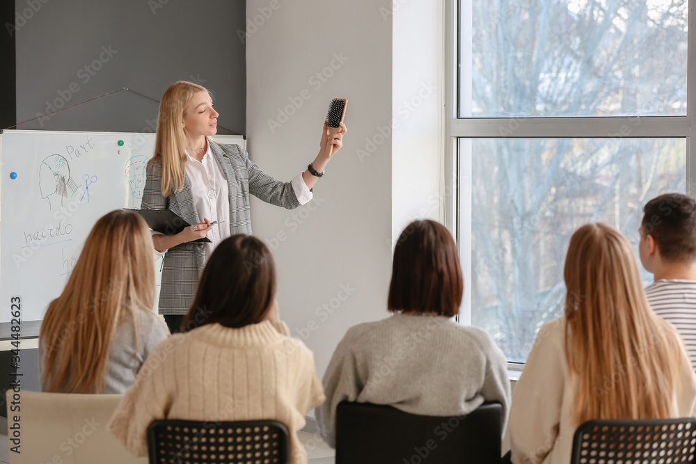 Professional hairdresser teaching young people in office