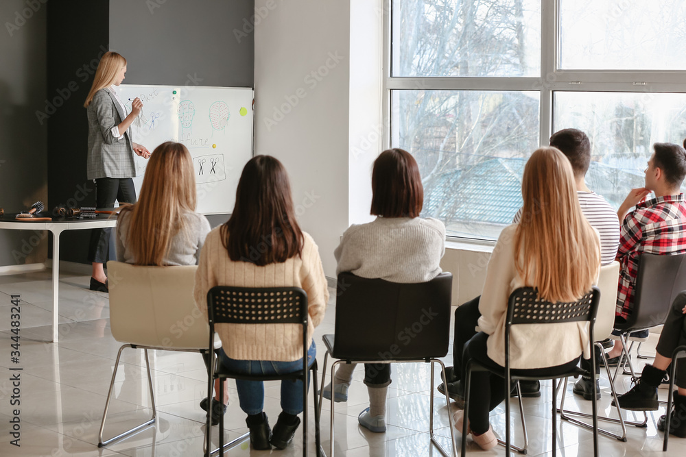 Professional hairdresser teaching young people in office