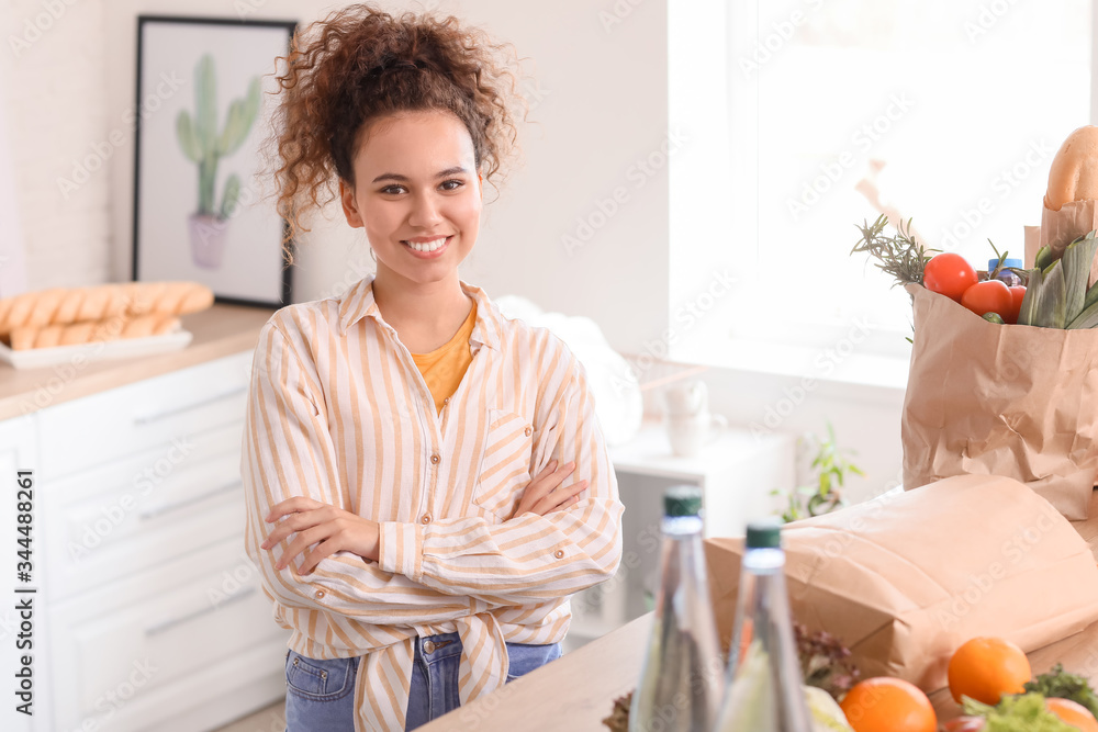 Young woman with fresh products from market at home