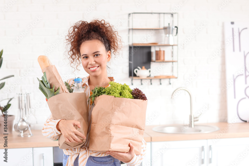 Young woman with fresh products from market at home